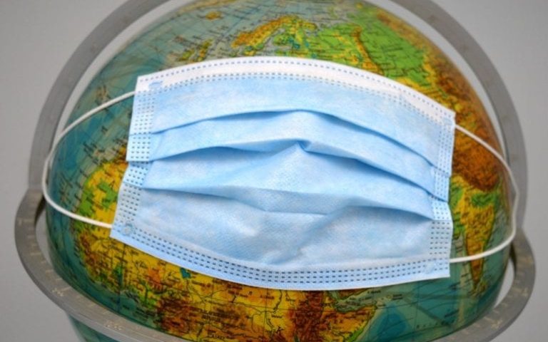 surgical facemask on top of a globe